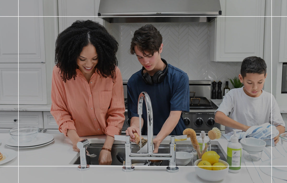 Family washing dishes together in a kitchen
